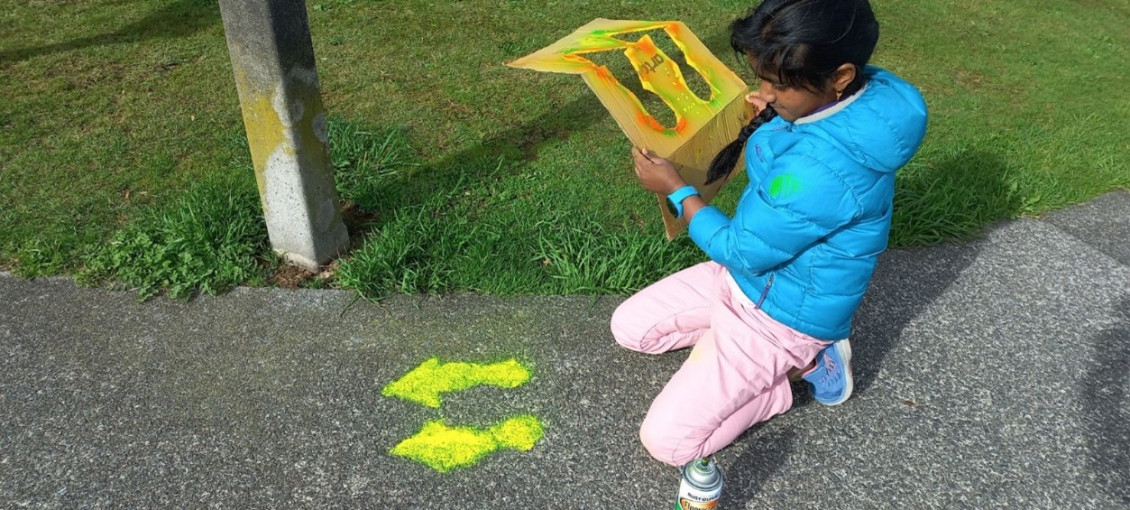 Papakowhai Student Animitra paints “farrows” on the footpath outside school